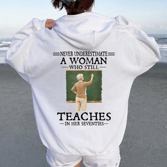 Never Underestimate Woman Who Still Teaches In Her Seventies Women Oversized Hoodie Back Print - Seseable