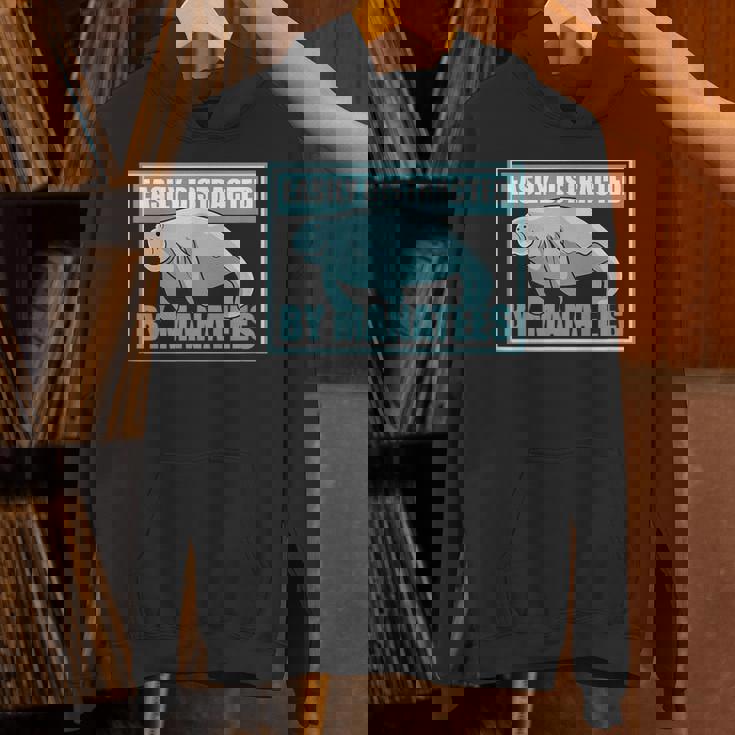 マナティーに気を取られる かわいいマナティー 面白い 海の動物 パーカー