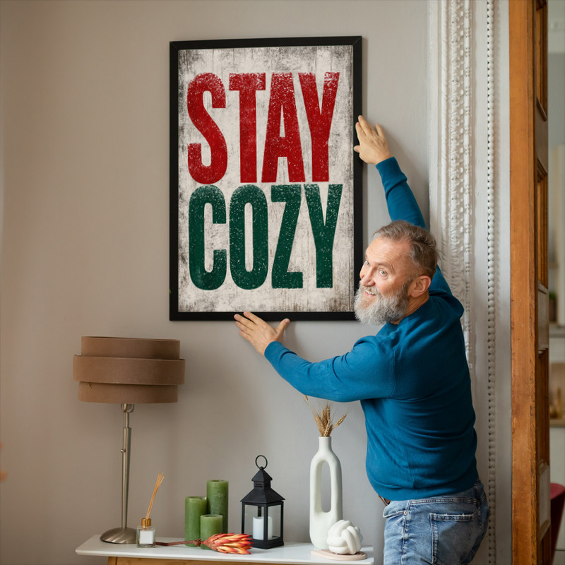 Christmas canvas wall art in rustic red and forest green, snowy script reads 'Stay Cozy', square format suited to dorm walls